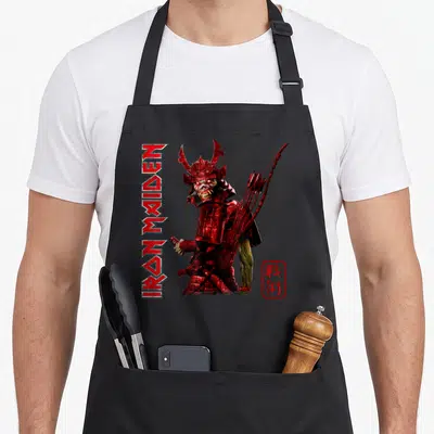 Tablier de cuisine noir avec un samouraï squelettique en armure rouge, le texte vertical Iron Maiden et un sceau japonais.
