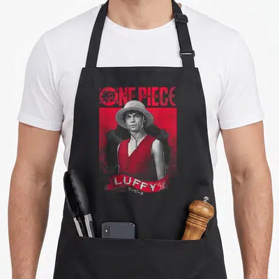 Tablier de cuisine noir avec portrait gravé de Luffy One Piece en rouge et gris, logo et nom imprimés.