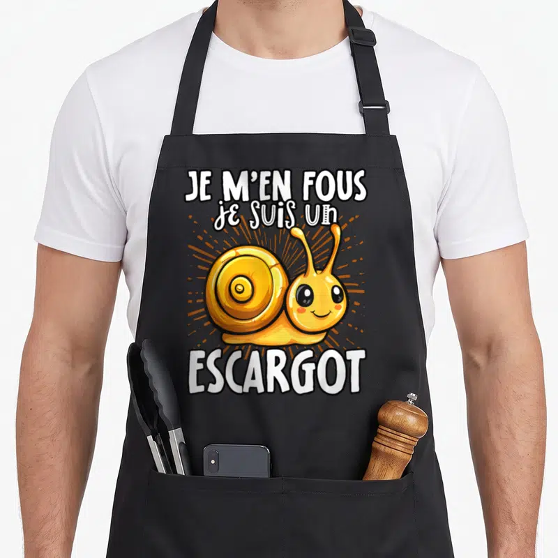 Tablier de cuisine noir avec un escargot jaune souriant et le texte Je m'en fous je suis un escargot imprimé au centre.