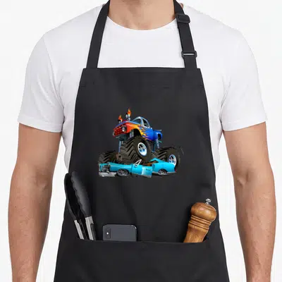 Tablier de cuisine noir avec Monster Truck bleu écrasant une voiture et des flammes orange sur le capot.