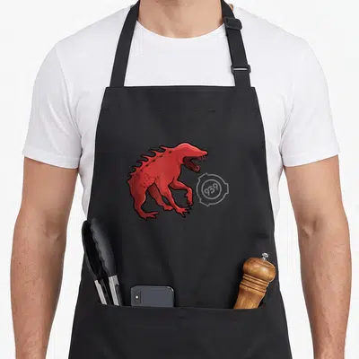 Tablier de cuisine noir avec une illustration d'une créature rouge à dents acérées et crêtes dorsales.