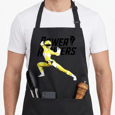 Tablier de cuisine noir avec l'illustration du Power Ranger jaune en position de combat et le logo Power Rangers en arrière-plan.