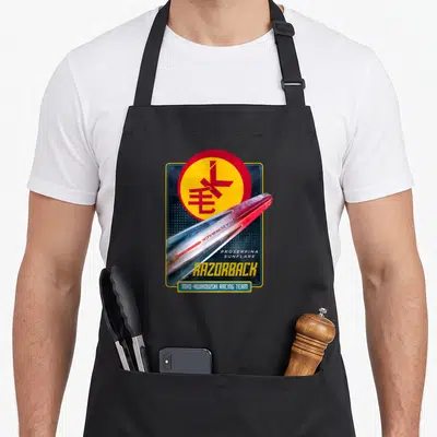 Tablier de cuisine noir avec illustration vaisseau Razorback Mao-Kwikowski Racing Team et logo circulaire jaune rouge.