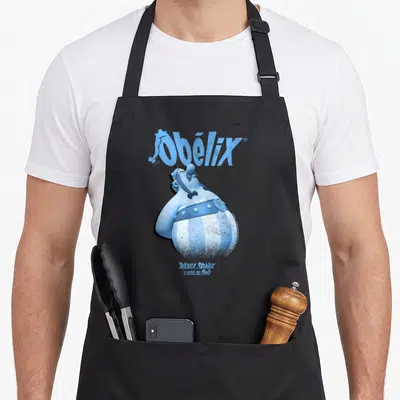 Tablier de cuisine noir avec une illustration bleue d'Obélix regardant vers le haut et son nom en grandes lettres au-dessus.