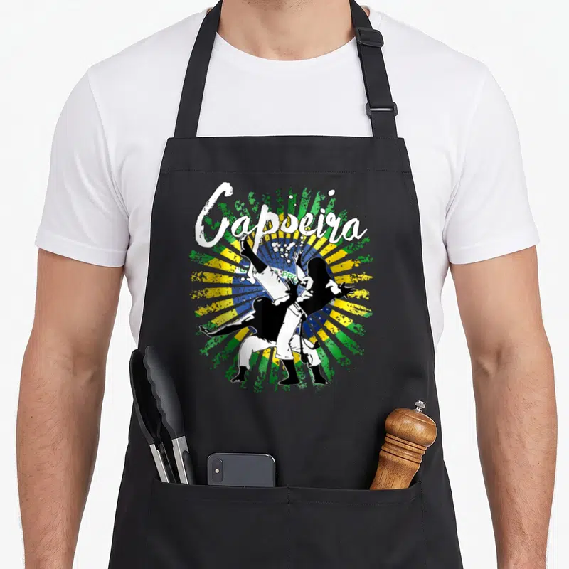 Tablier de cuisine noir avec illustration de deux pratiquants de capoeira et le mot Capoeira en blanc.