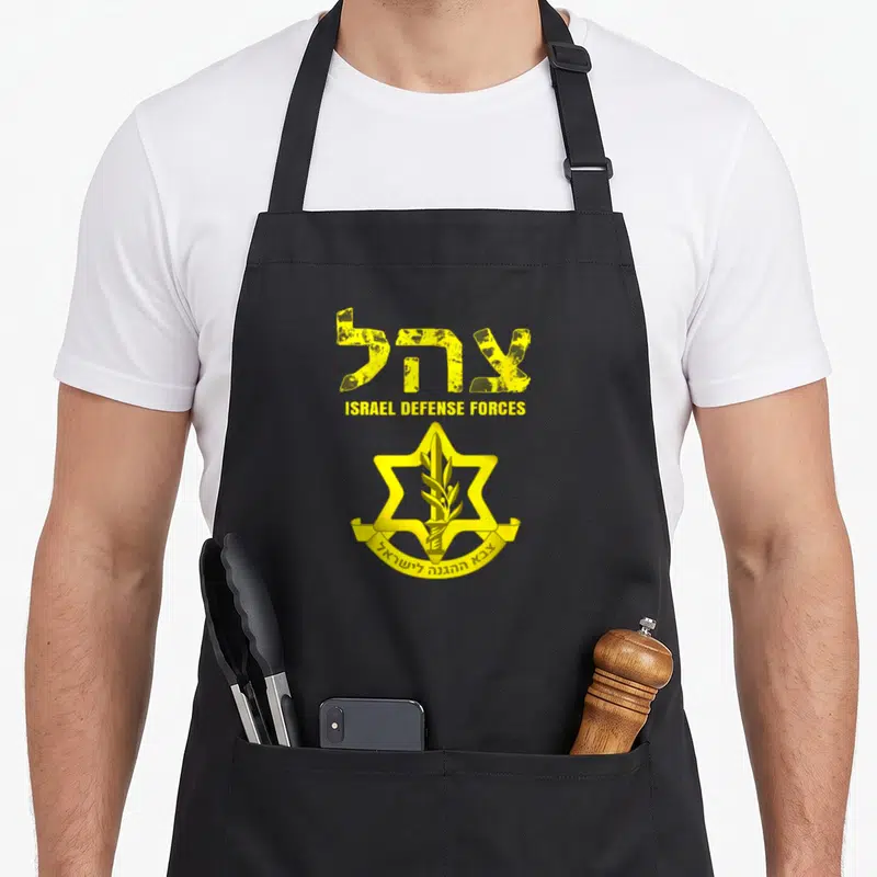 Tablier de cuisine noir avec insigne jaune des forces de défense d'Israël et texte en hébreu et anglais.