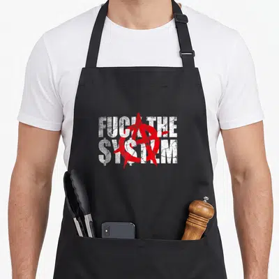 Tablier Fuck The System — sur un tablier de cuisine noir, fond blanc
