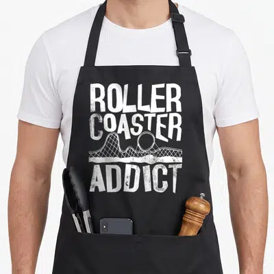 Tablier de cuisine noir avec inscription blanche roller coaster addict et dessin de voie de montagnes russes.