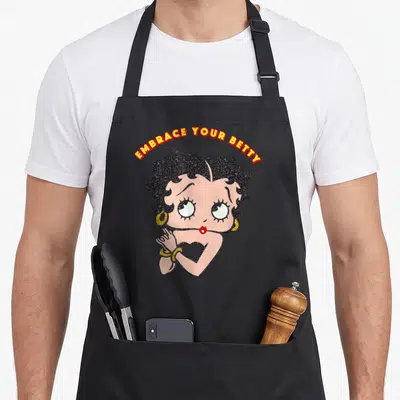 Tablier de cuisine noir avec illustration colorée de Betty Boop et texte Embrace Your Betty en haut.
