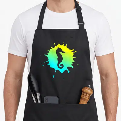 Tablier de cuisine noir avec silhouette d'hippocampe grise sur fond d'éclaboussure jaune et turquoise.