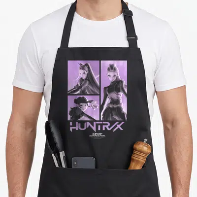 Tablier de cuisine noir avec illustration violette du personnage Huntrix et le texte Huntrax Kpop Demon Hunters en bas.