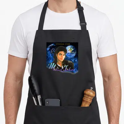 Tablier de cuisine noir avec portrait de Michael Jackson, Terre en arrière-plan et texte Eternal Star en lettres dorées.