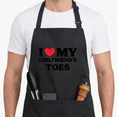 Tablier de cuisine noir avec texte I love my girlfriend's toes et un cœur rouge au centre