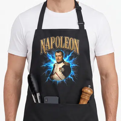 Tablier de cuisine noir avec illustration de Napoléon et éclairs bleus sous le texte NAPOLEON