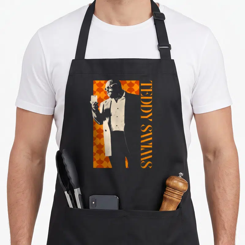 Tablier de cuisine noir avec illustration de Teddy Swims tenant un verre sur fond orange géométrique