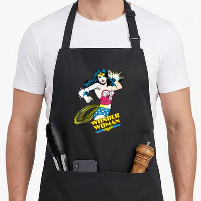 Tablier de cuisine noir avec Wonder Woman style vintage DC Originals et son lasso doré en mouvement.