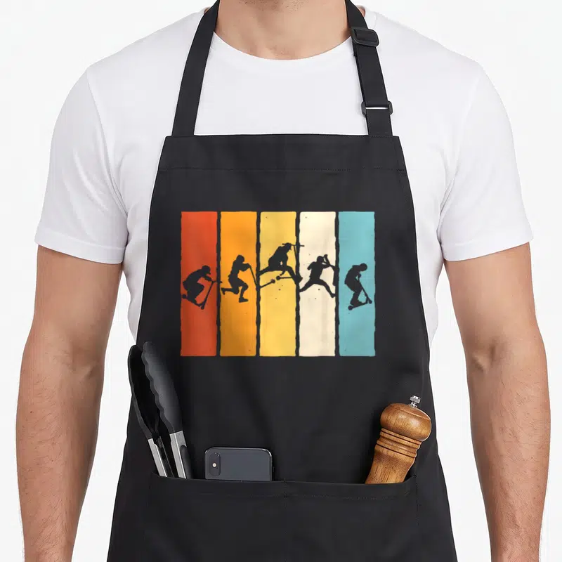 Tablier de cuisine noir avec cinq bandes verticales colorées affichant des silhouettes de trottinette freestyle en action.