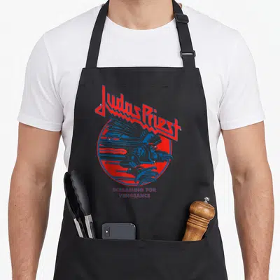 Tablier de cuisine noir avec le logo Judas Priest et un aigle bleu stylisé dans un cercle rouge.