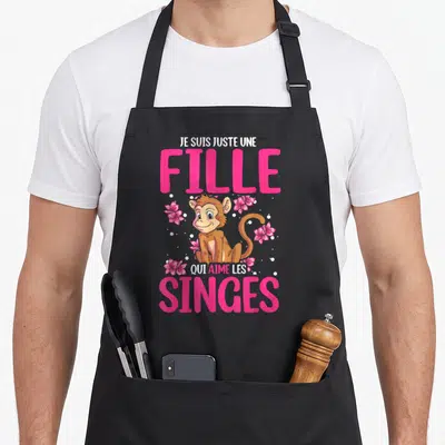 Tablier de cuisine noir avec illustration de singe entouré de fleurs roses et texte en rose vif.
