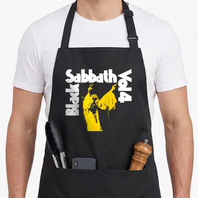 Tablier de cuisine noir avec typographie White Sabbath Vol 4 et silhouette jaune stylisée au centre du vêtement.