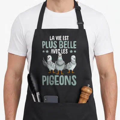 Tablier de cuisine noir avec trois pigeons gris et le texte la vie est plus belle avec les pigeons imprimé en blanc et vert clair.
