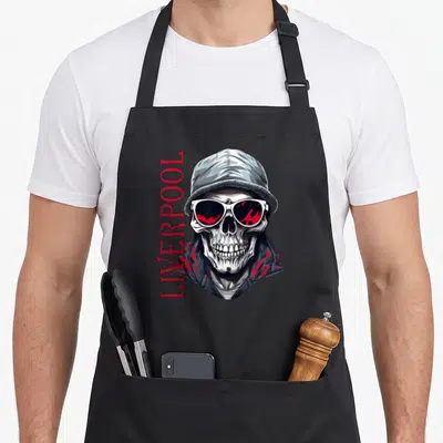 Tablier de cuisine noir avec illustration de crâne portant une casquette et des lunettes à verres rouges reflétant du sang.