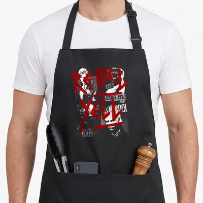 Tablier de cuisine noir avec inscription Rebel Yell en rouge et visages de Billy Idol en blanc et gris.