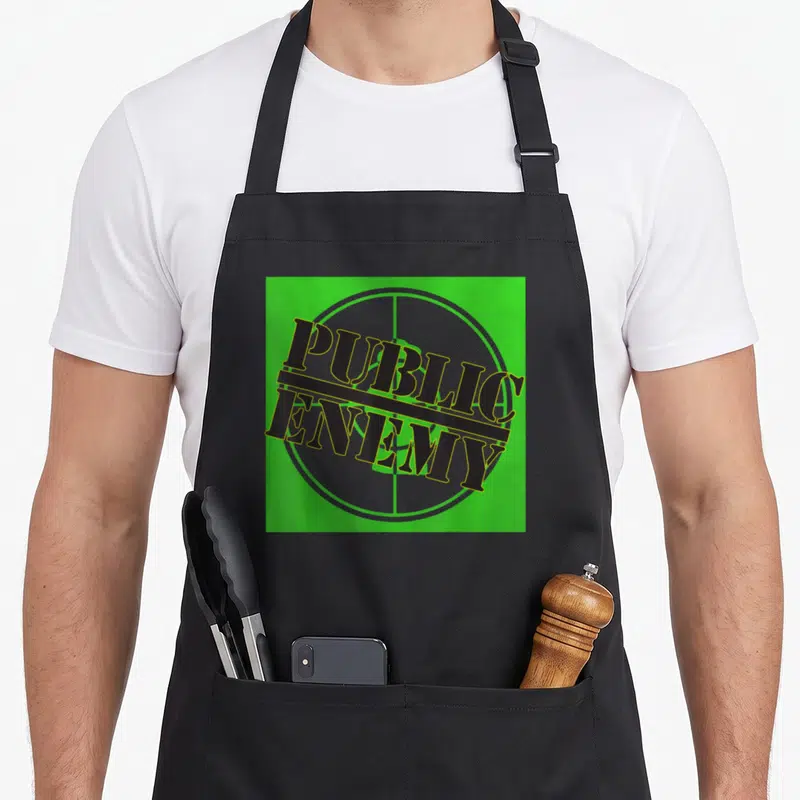 Tablier de cuisine noir avec le logo vert Public Enemy sur fond de cible grise.