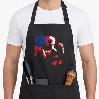 Tablier de cuisine noir avec illustration stylisée de Billy Idol et texte Idol Rebel Yell en rouge et bleu.
