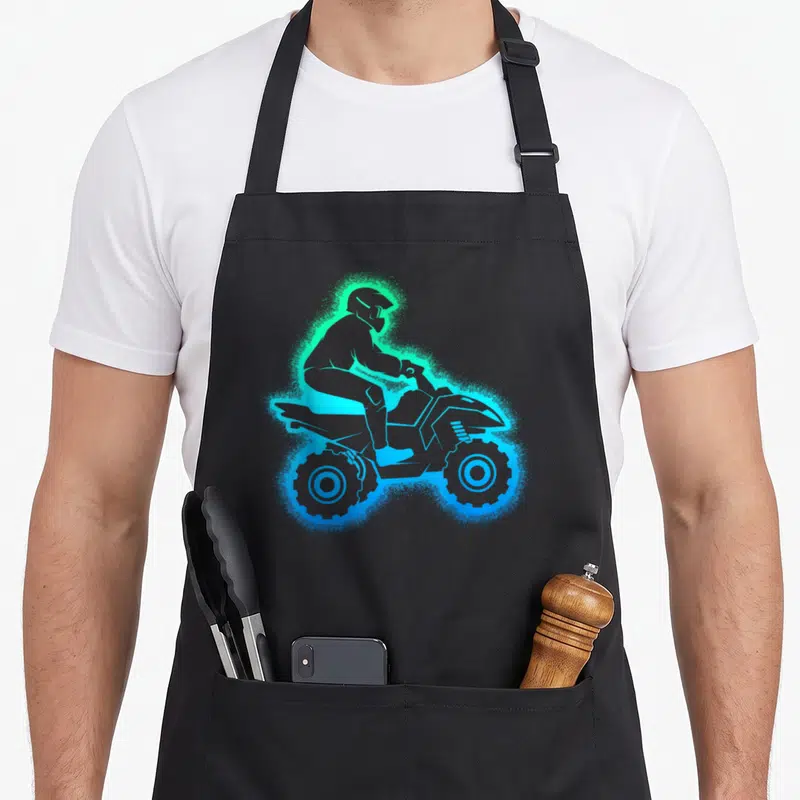Tablier de cuisine noir avec illustration néon d'un quad homme enfant aux teintes vertes et bleues lumineuses.