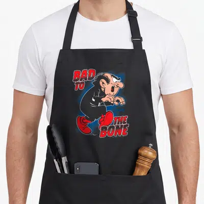 Tablier de cuisine noir avec illustration de Gargamel et texte Bad to the Bone Smurfs en rouge et bleu.