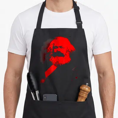 Tablier de cuisine noir avec portrait stylisé en rouge vif de Karl Marx aux traits épurés et à la barbe fournie.