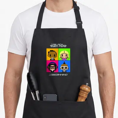 Tablier de cuisine noir avec quatre visages pixel art sur carrés colorés et le titre The Beginning imprimé en blanc.