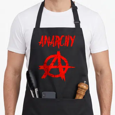 Tablier de cuisine noir avec le texte Anarchy et un symbole circulaire rouge stylisé au centre du vêtement.