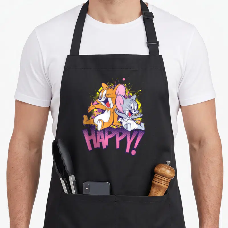 Tablier de cuisine noir avec Jerry et Nibbles souriants et le mot HAPPY en lettres roses stylisées.