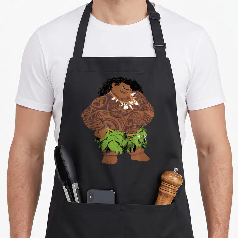 Tablier de cuisine noir avec une illustration colorée de Maui debout les mains sur les hanches.