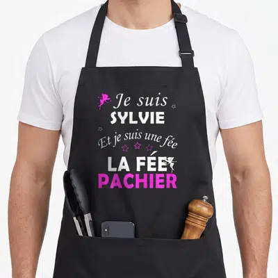 Tablier de cuisine noir avec inscription Je suis Sylvie fée pachier et petits cupons roses.