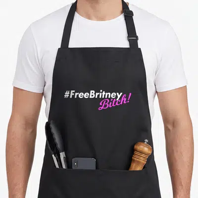 Tablier de cuisine noir avec l'inscription #FreeBritney Bitch en typographie blanche et rose vif.
