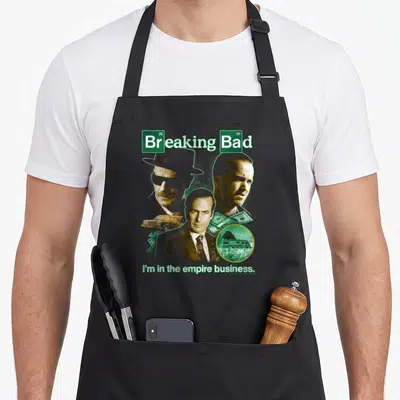 Tablier de cuisine noir avec collage Breaking Bad portraits et phrase I'm in the empire business en vert.