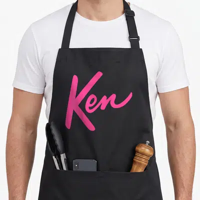 Tablier de cuisine noir avec le mot Ken écrit en rose vif dans une typographie manuscrite dynamique.