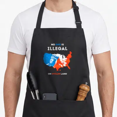 Tablier de cuisine noir avec une carte des USA bleue et rouge portant les mots No One Is Illegal On Stolen Land