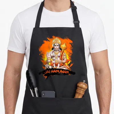Tablier de cuisine noir avec une illustration colorée de Hanuman et le texte Jai Hanuman en orange.