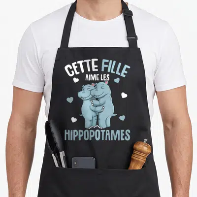 Tablier de cuisine noir avec deux hippopotames bleus s'embrassant et le texte cette fille aime les hippopotames enfants.