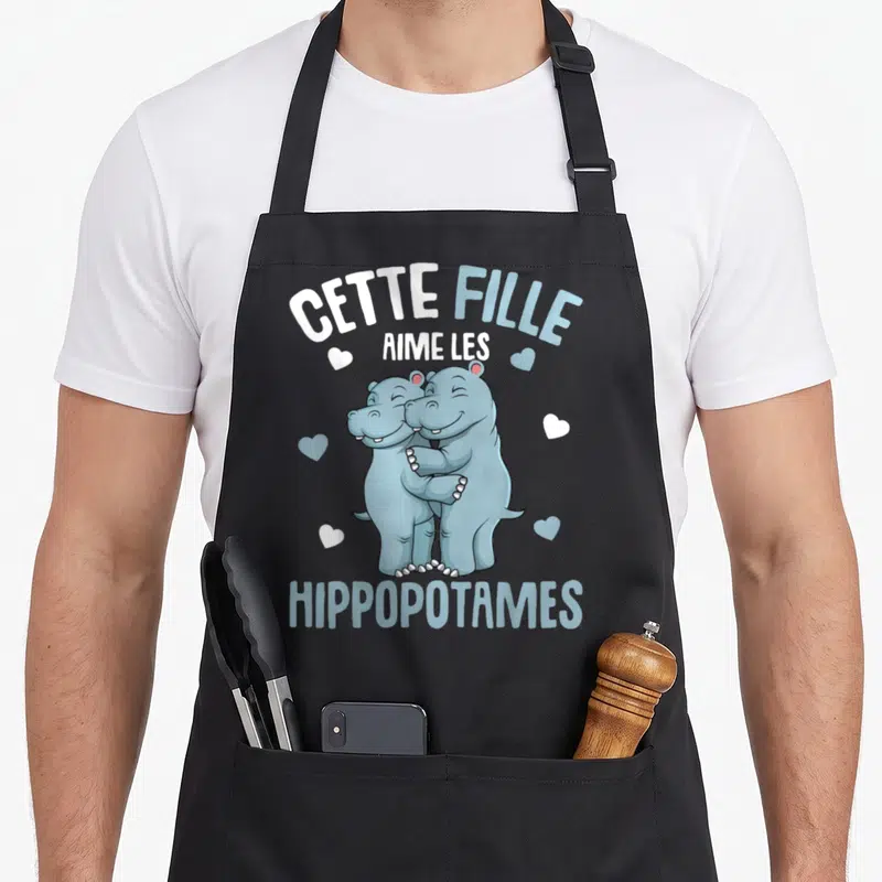 Tablier de cuisine noir avec deux hippopotames bleus s'embrassant et le texte cette fille aime les hippopotames enfants.