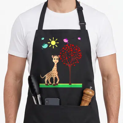 Tablier de cuisine noir avec une girafe souriante, un arbre à cœurs rouges et des oiseaux sous un soleil jaune.