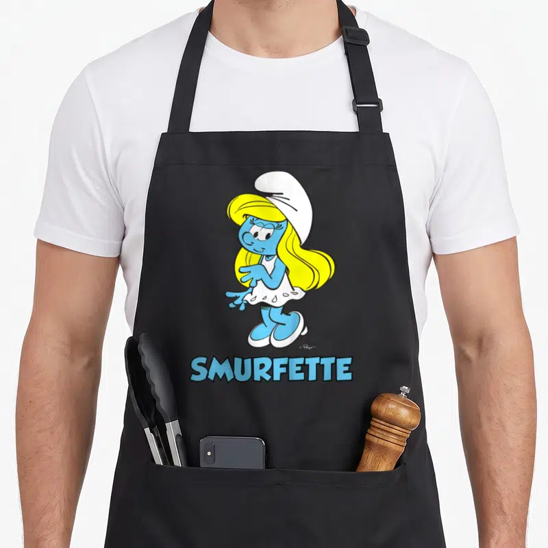 Tablier de cuisine noir avec une illustration colorée de Smurfette et le mot SMURFETTE imprimé en dessous.