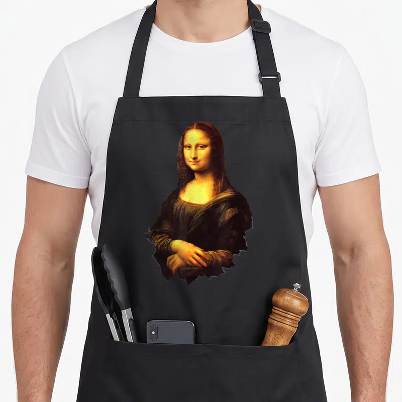 Tablier de cuisine noir avec l'impression du portrait de La Gioconda aux tons chauds et au fond uni gris.