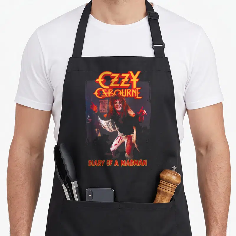 Tablier de cuisine noir avec illustration Ozzy Osbourne et texte Diary of a Madman en orange.