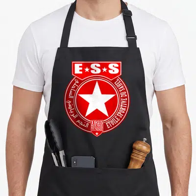 Tablier de cuisine noir avec le logo rouge et blanc de l'Etoile Sportive du Sahel et une grande étoile blanche centrale.
