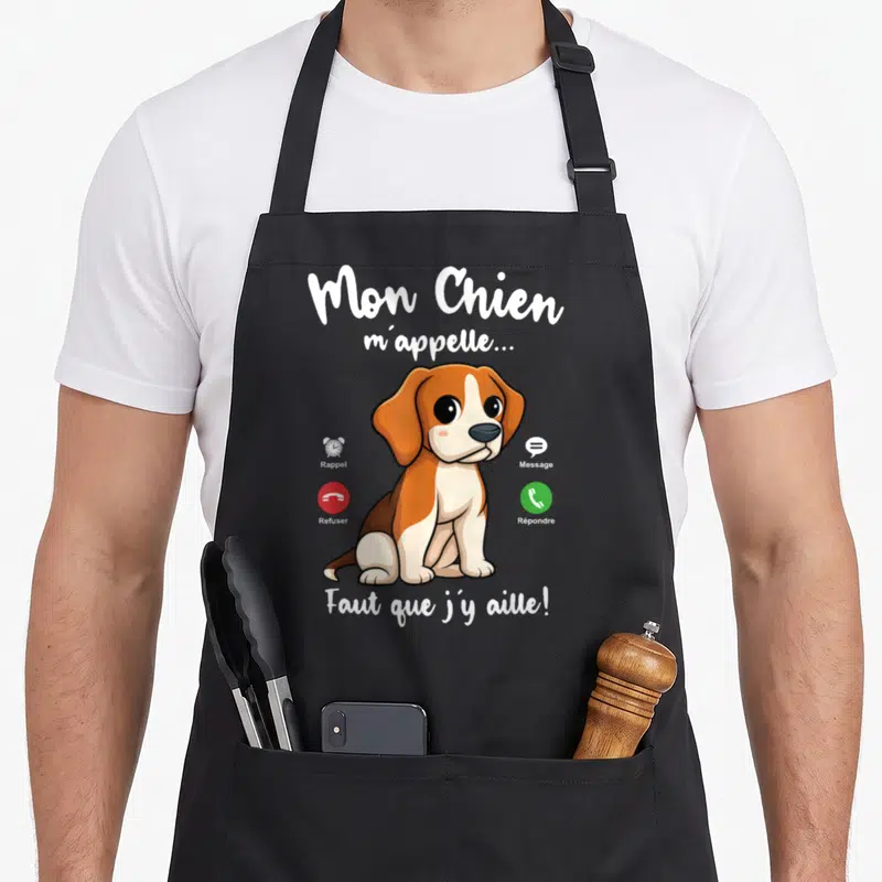 Tablier de cuisine noir avec illustration d'un chiot beige et marron entouré d'icônes de rappel et de message.
